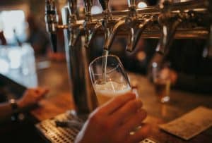 Pint of lager being poured from a row of bar taps