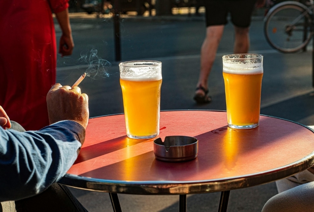 Friends clinking pint glasses of lager and ale together