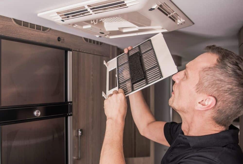 Cleaning an air conditioning filter as part of routine caravan maintenance