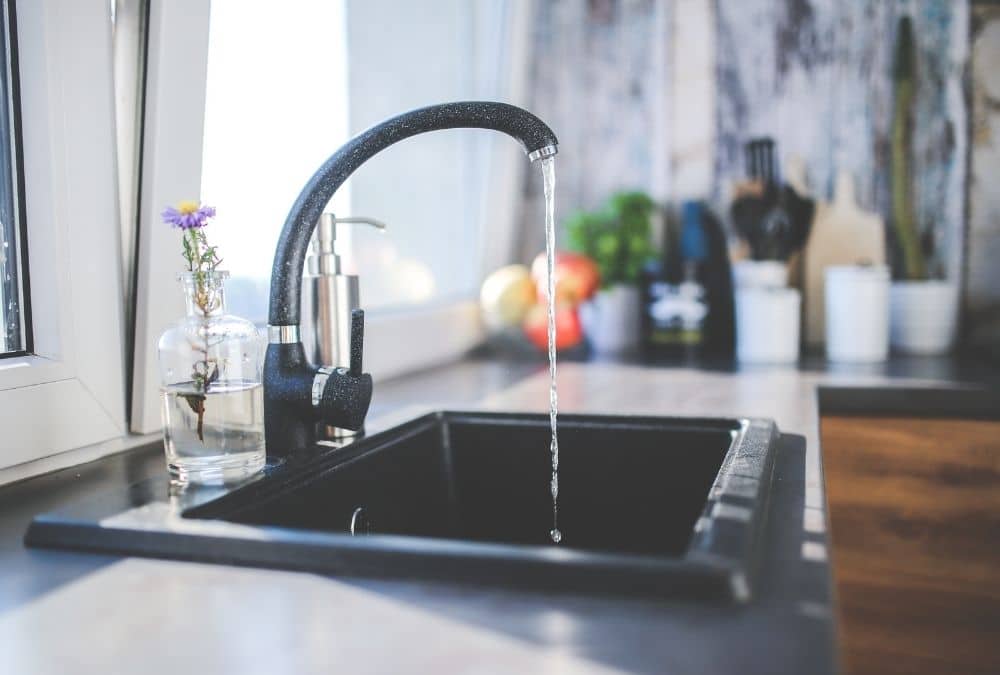 Running water from a caravan kitchen tap demonstrating utility and water supply requirements