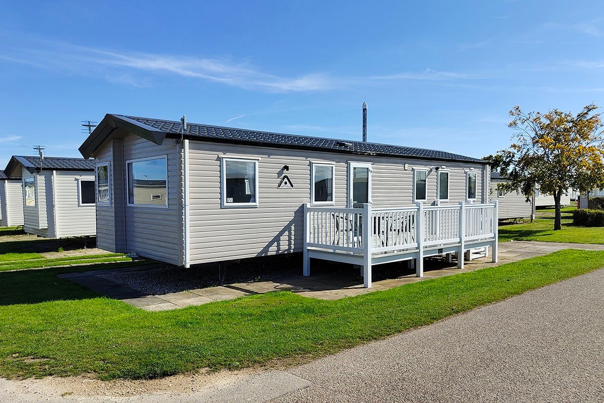 Caravans for sale Skegness Exterior view of the Premium 3 Bedroom Caravan, featuring steps leading up to a spacious decking area, offering a welcoming entrance.