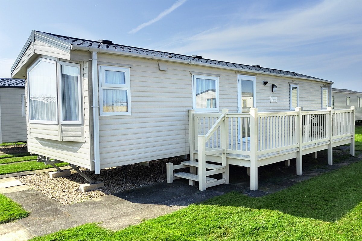 static caravans for sale Exterior of a Premium Pet-Friendly 2 Bedroom Caravan featuring steps, elegant decking, and a charming holiday setting.