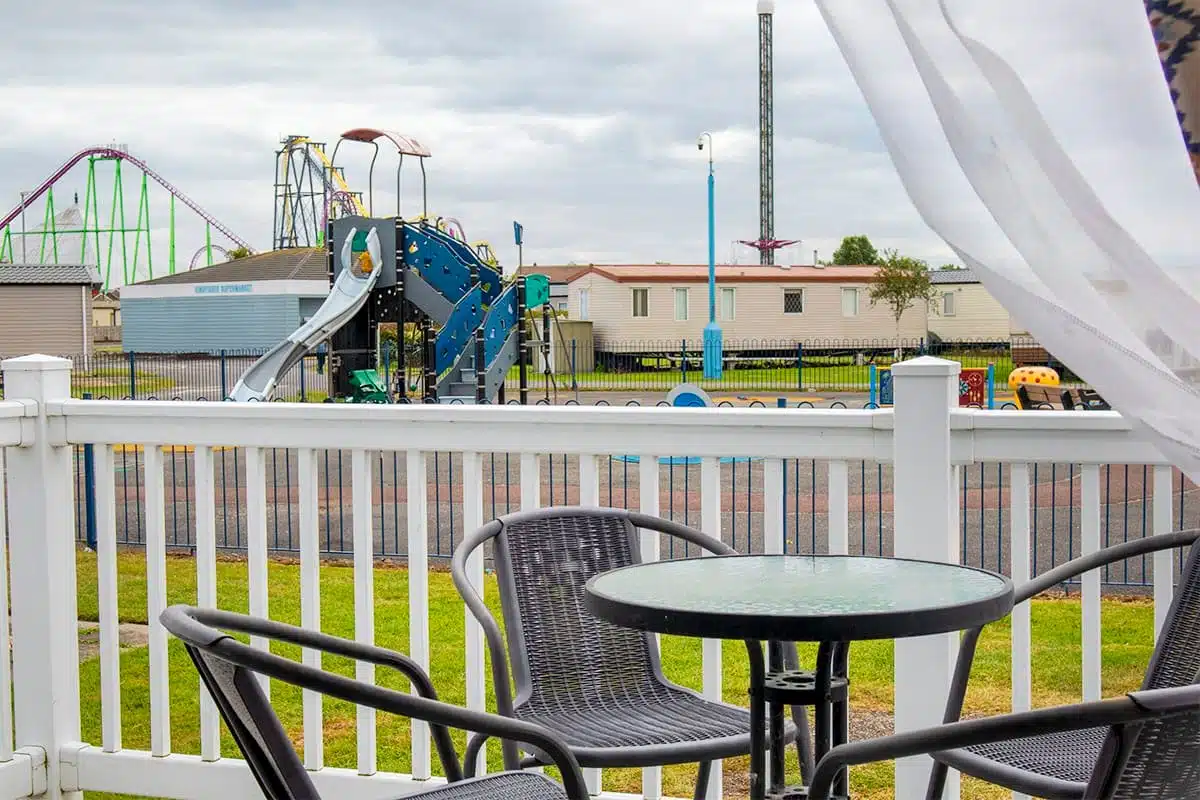 holiday homes Lincolnshire Premium Plus 2 Bedroom Pet-Friendly Caravan decking with outdoor furniture, perfect for relaxing while enjoying views of Fantasy Island in the background.