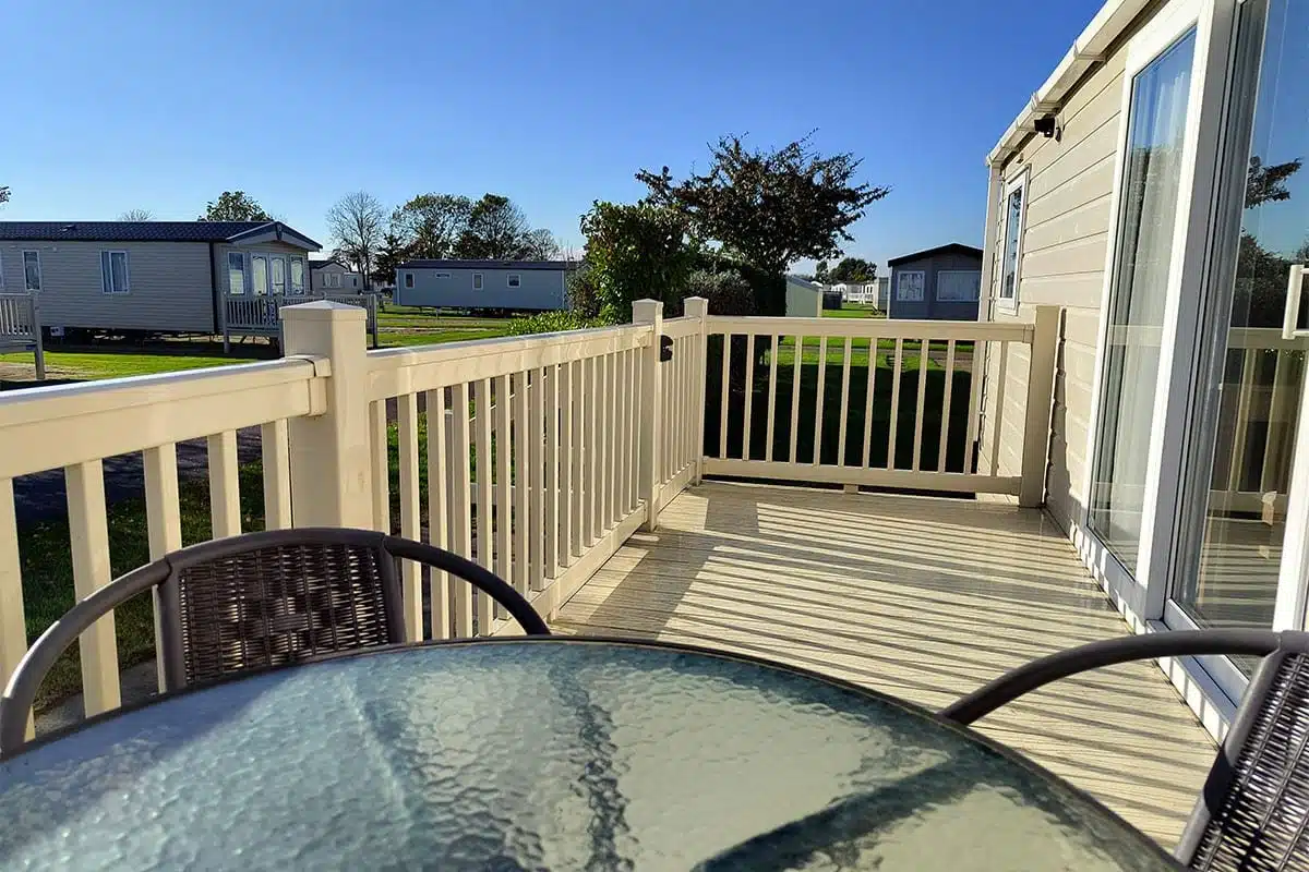 weekend caravan breaks Decking area of Premium Plus 3 Bedroom Caravan with stylish outdoor furniture, overlooking the scenic Kingfisher Caravan Park.