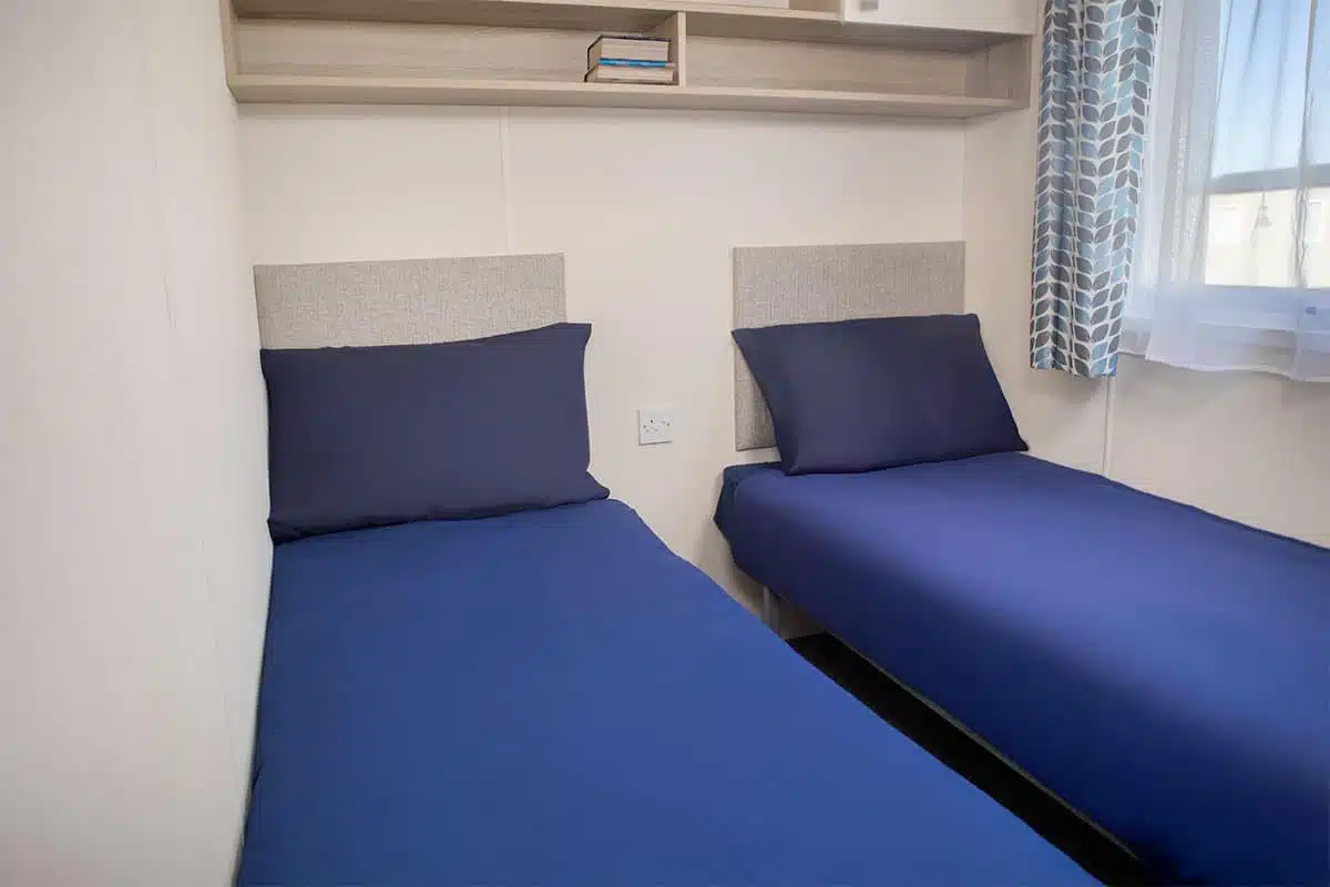 Second guest bedroom in Premium Plus 3 Bedroom Caravan with two single beds, designed for comfort and convenience.