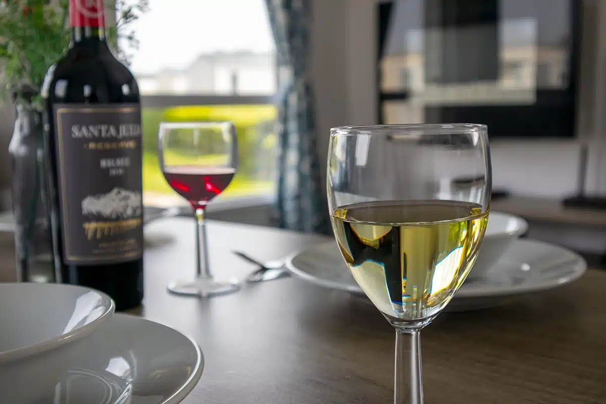 Dining table close-up in a Standard 3 Bedroom Caravan, featuring wine glasses for a perfect holiday meal.