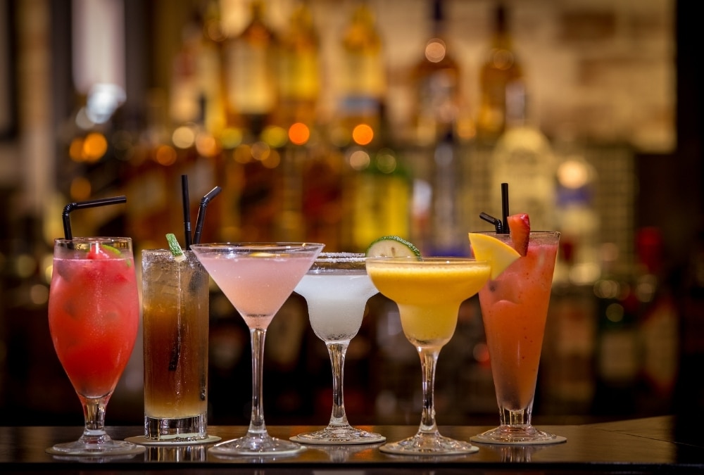 Selection of colourful cocktails lined up on a bar