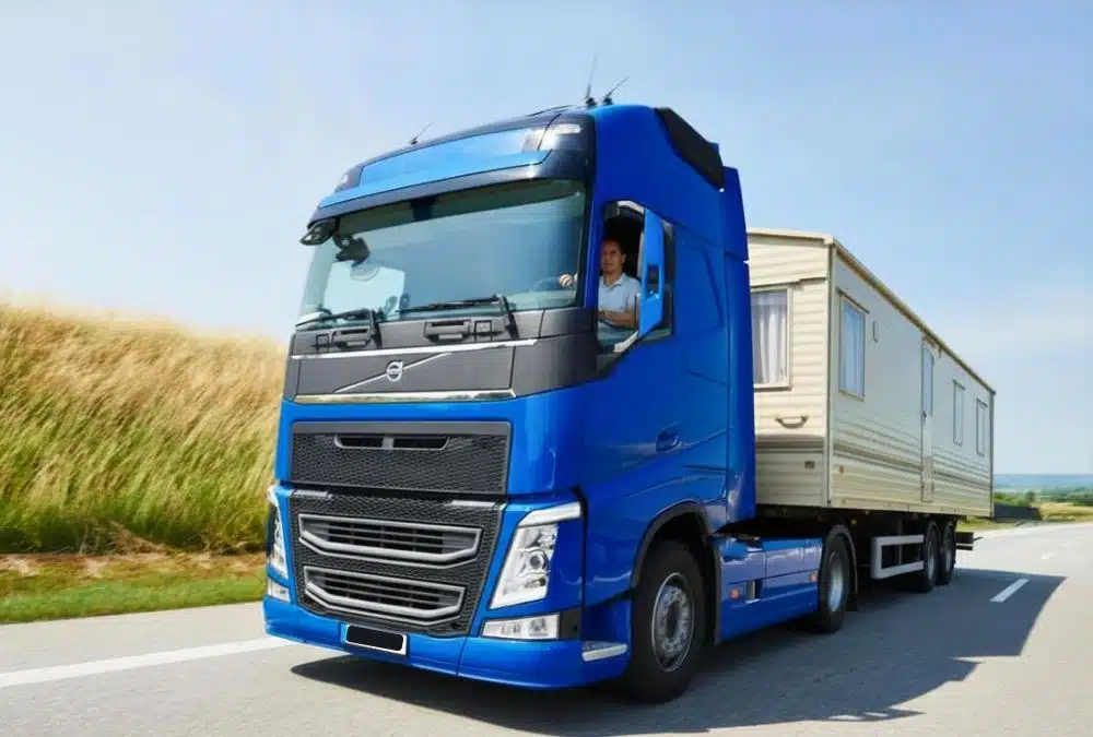 Large static caravan being moved by lorry on a UK road