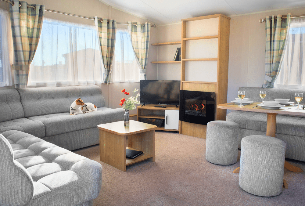 Bright, comfortable living area inside a static caravan with a dog relaxing on the sofa