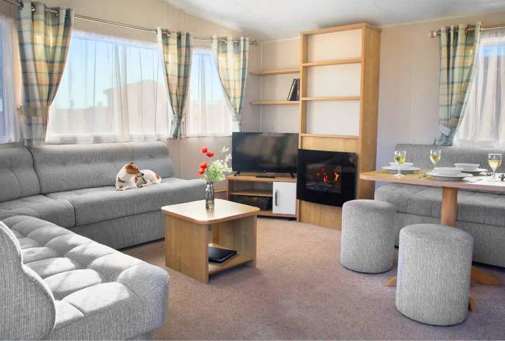 Bright, comfortable living area inside a static caravan with a dog relaxing on the sofa