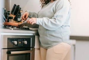 Woman cooking an easy one-pan meal on the hob in a static caravan kitchen