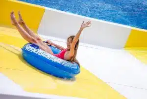 Girl riding an inflatable tube down a water park slide in Skegness