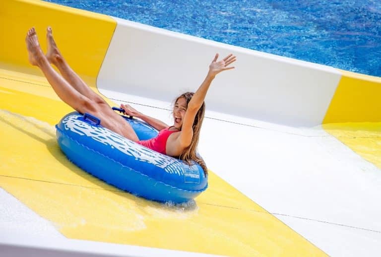 Girl riding an inflatable tube down a water park slide in Skegness